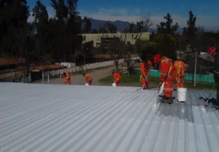 Aplicación de la primera capa de ENESEAL HR por parte de la cuadrilla de trabajo sobre las planchas de zinc.